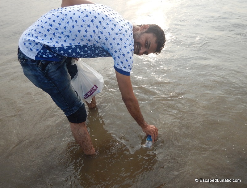 Azhar collecting seawater at Dandi Beach