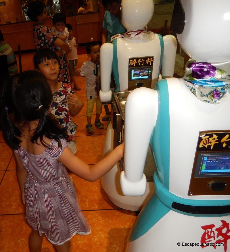 Children swarming around the Robowaitresses.