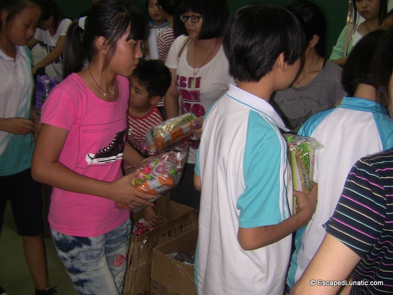 Members of the MilliCharity charity group giving candy to the children